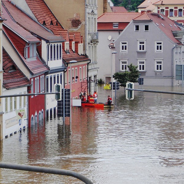 Rettungskräfte vor einem überfluteten Haus